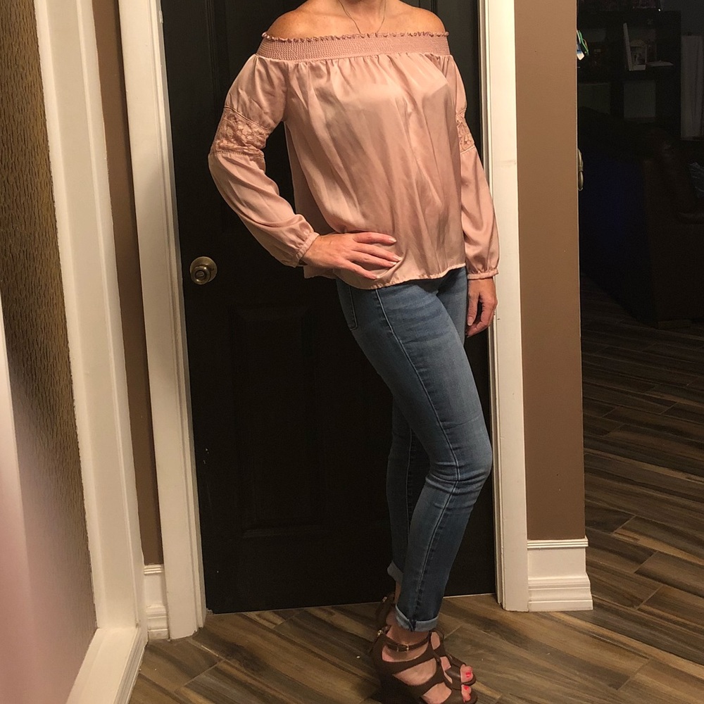 Off the shoulder pale pink long sleeve shirt.